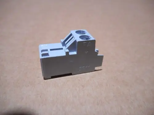 Grauer Stecker mit zwei Buchsen und einem Anschluss. Das Produkt gehört zur Marke Remeha und wird typischerweise in elektrischen Anwendungen verwendet.